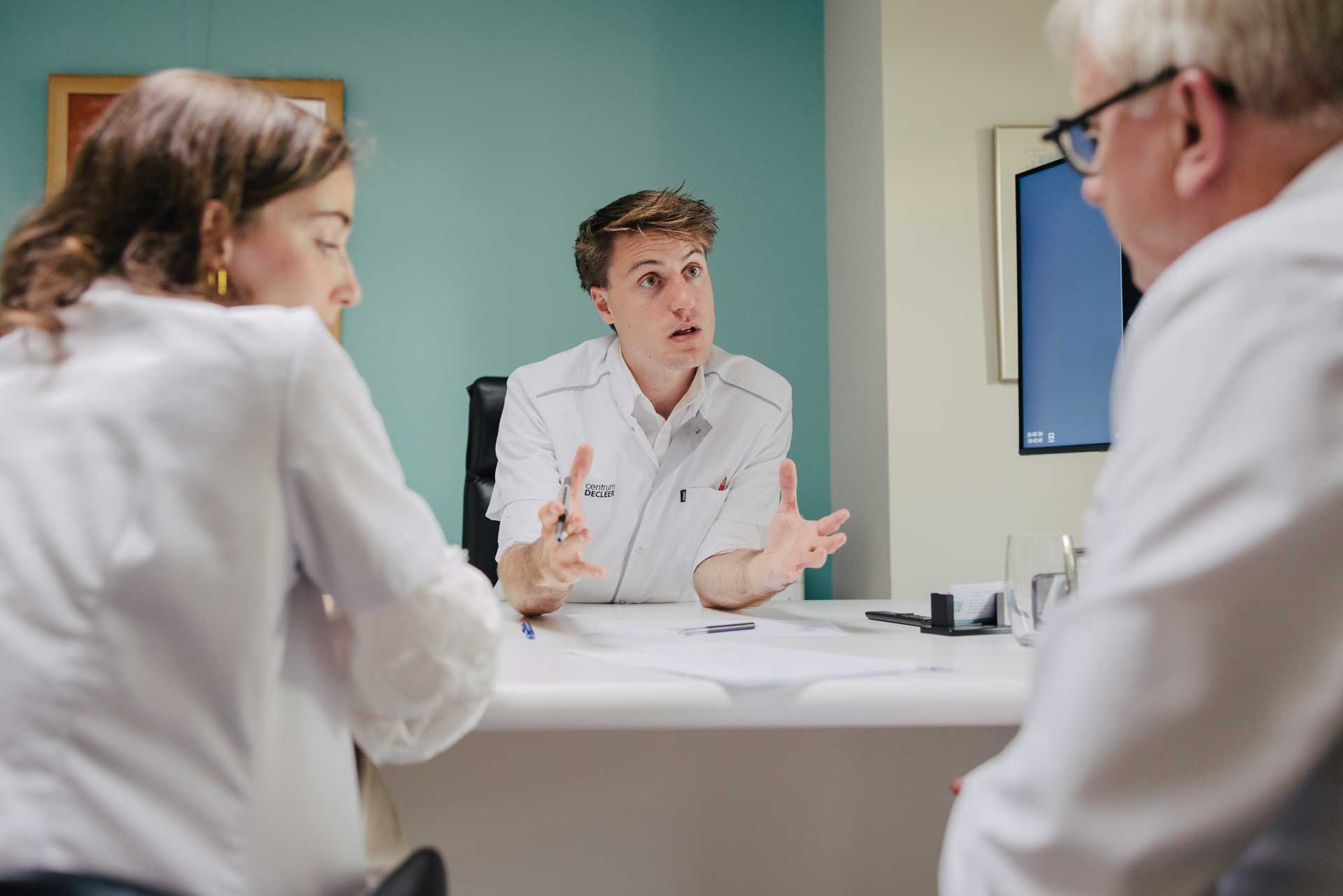Dr. Jonas Balduyck in gesprek met collega's aan een bureau
