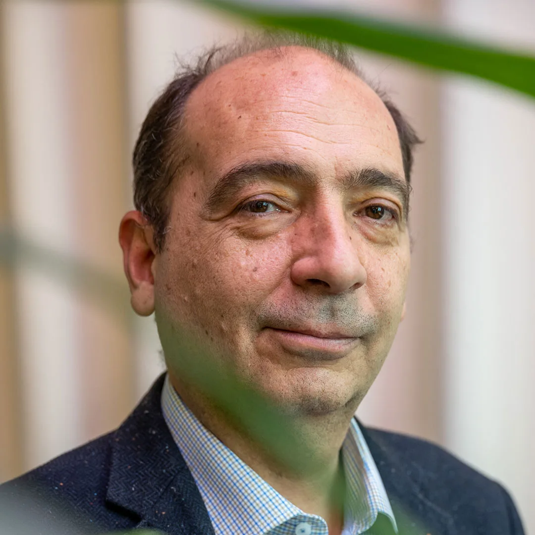 Portret van Prof. dr. Kaan Osmanagaoglu, lachend en in pak
