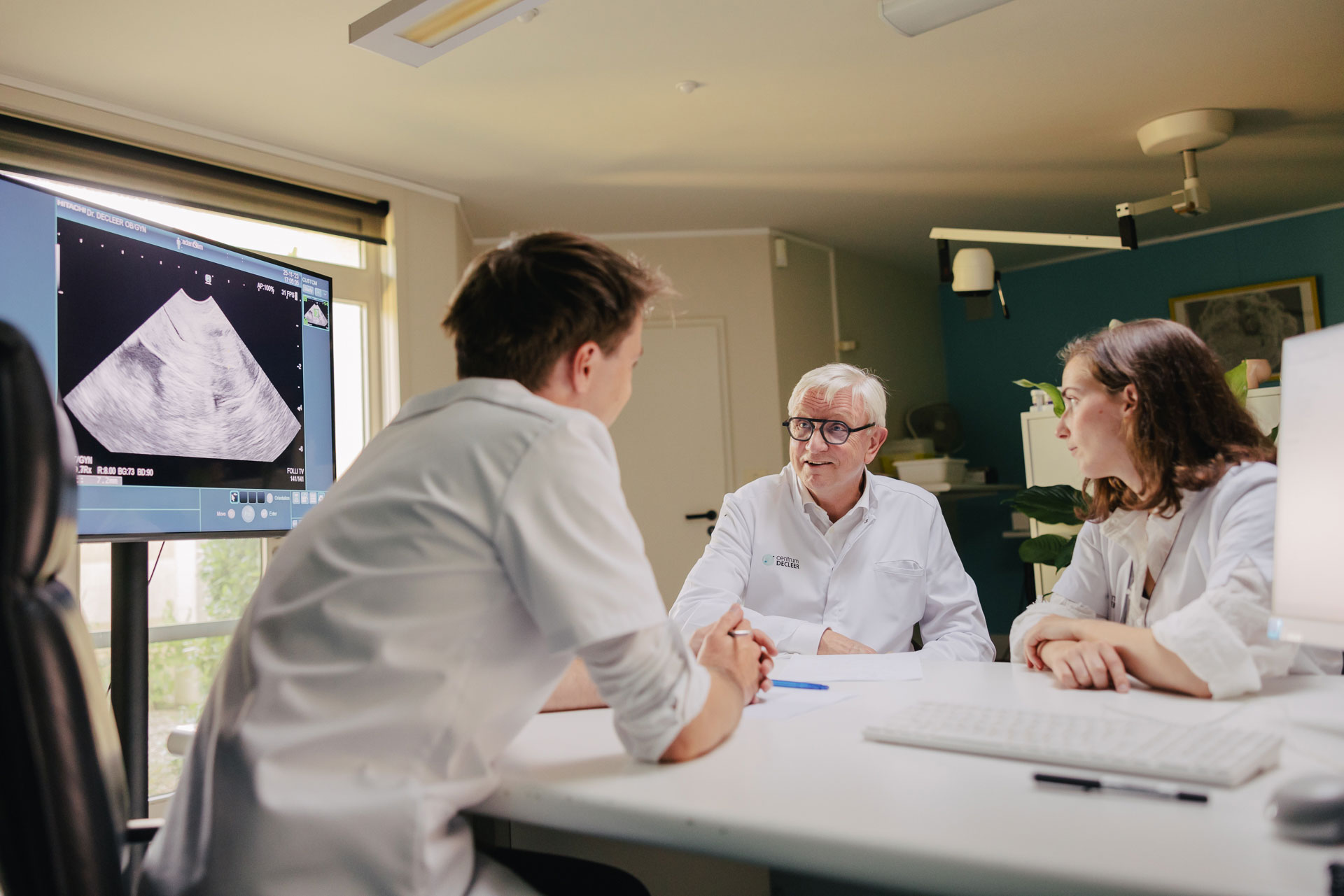 Artsen bespreken een echografie in een endocrinologie en andrologie praktijk.